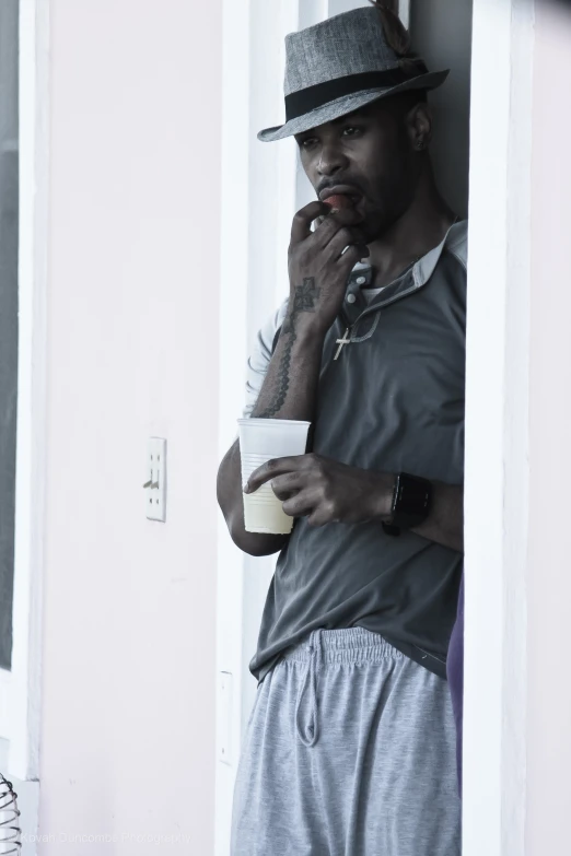 a man smoking while looking through the window