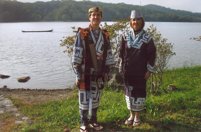 two people posing near the water at a campsite