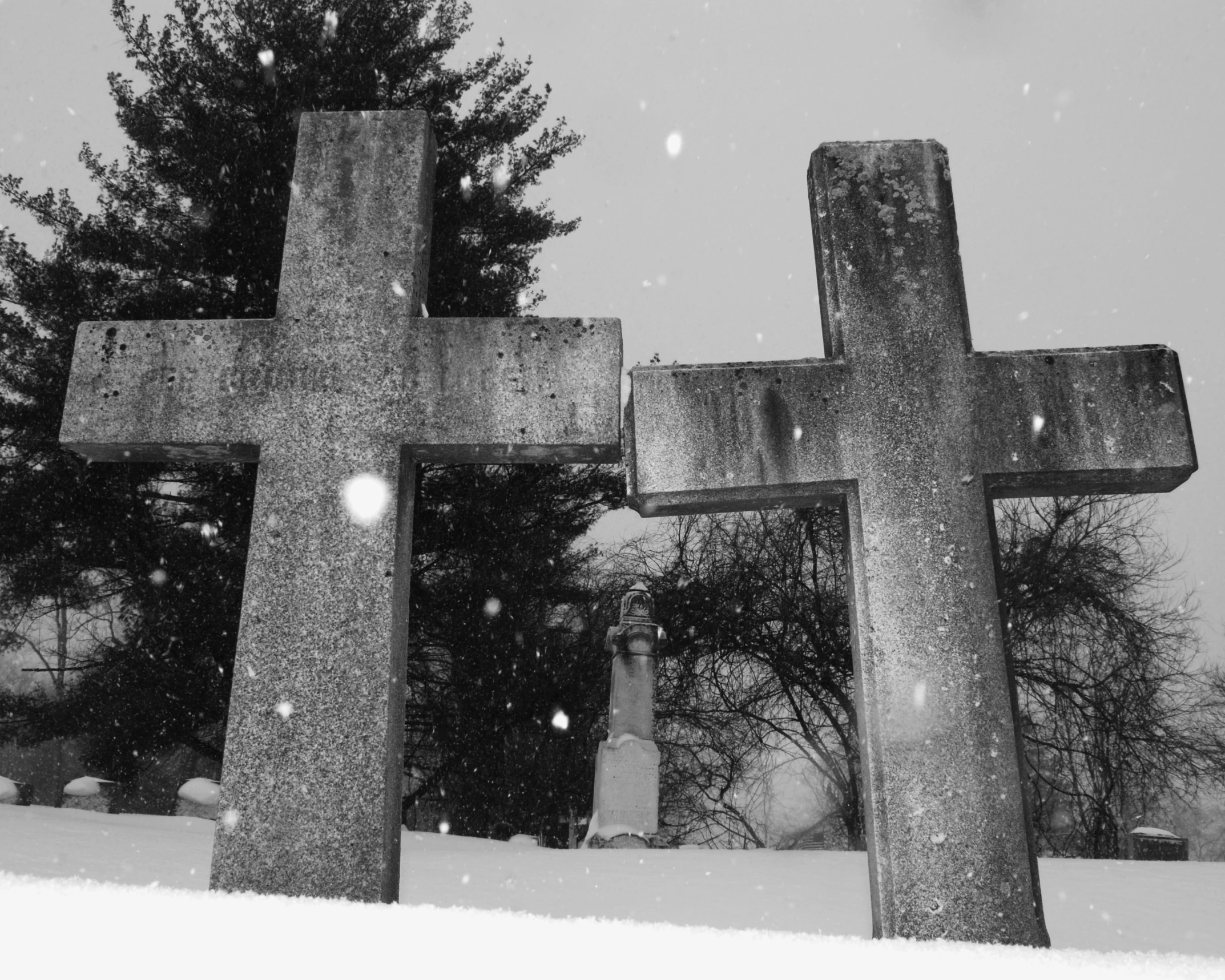 an old cross sitting in the middle of the snow