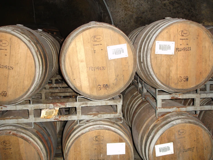 large batches of wine barrels stacked up in a storage area