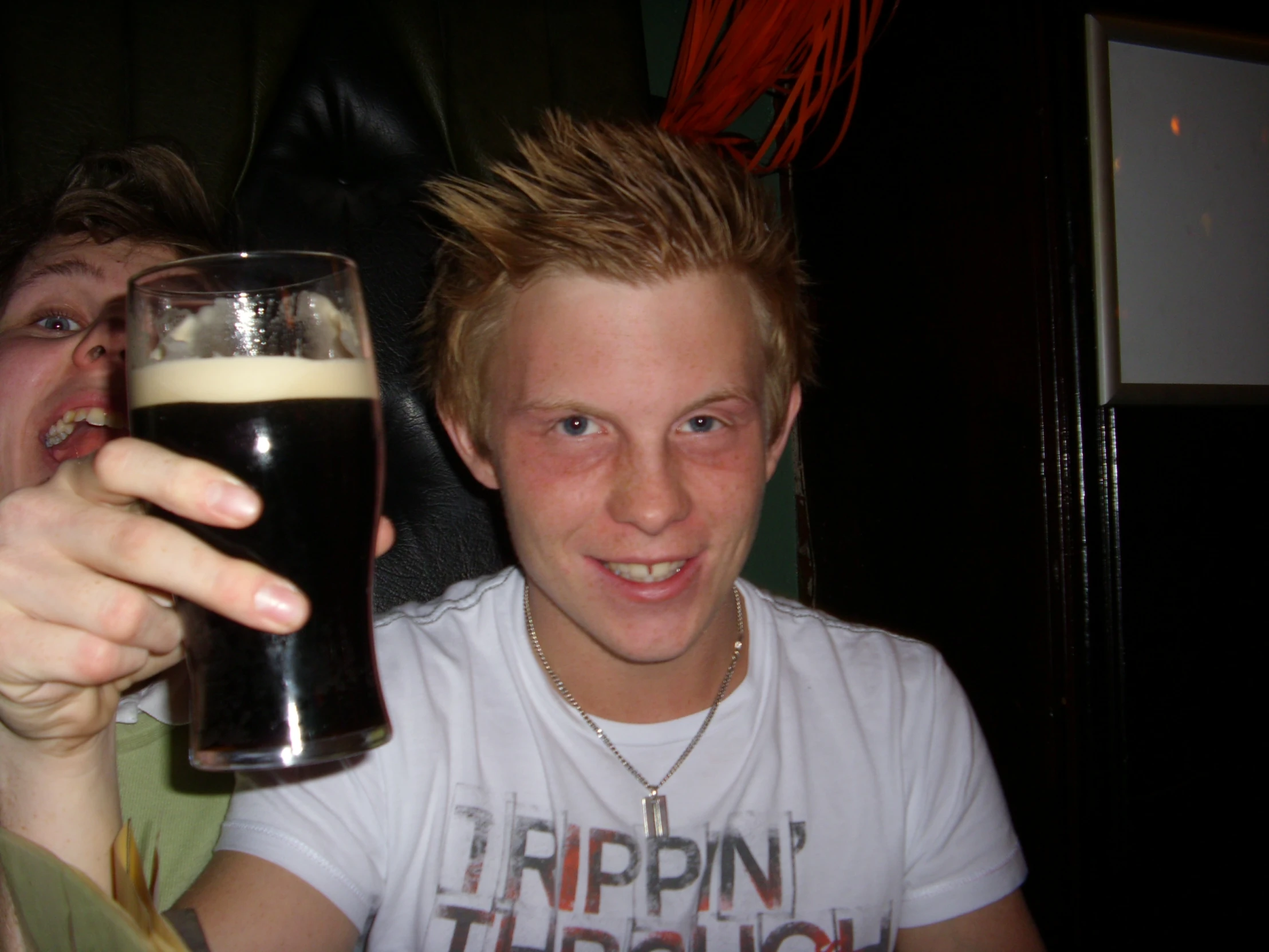 a man that is sitting down with a glass in his hand