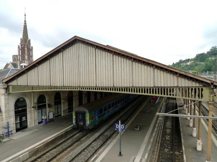 train station with train and tracks at the platform