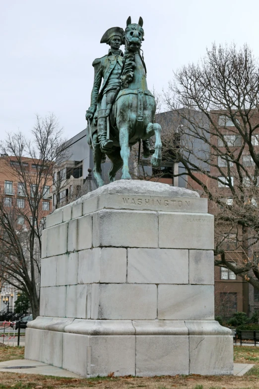 a sculpture on a pedestal in a city park