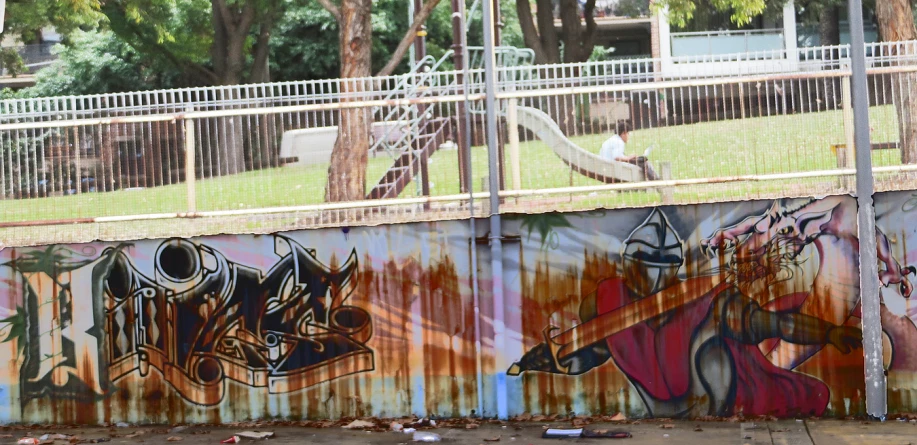 a large rusted wall with lots of graffiti on it