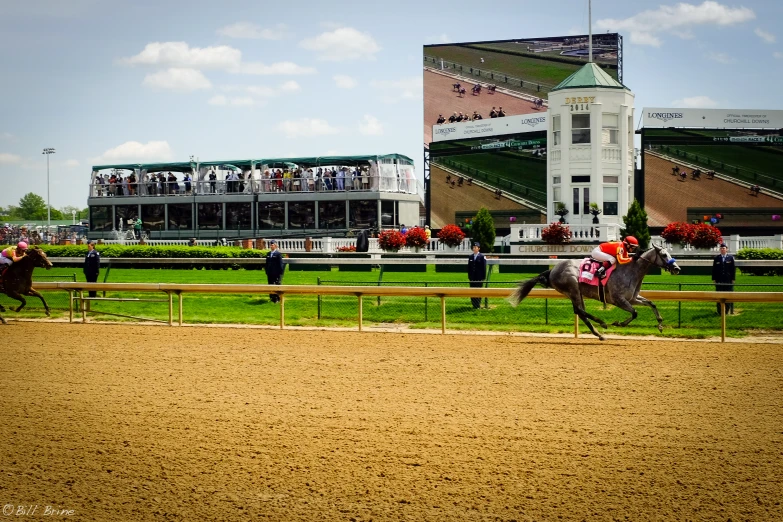 horse racing at a race track in front of a building