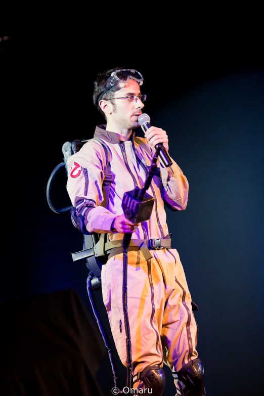 a man in an orange jumpsuit standing next to a microphone