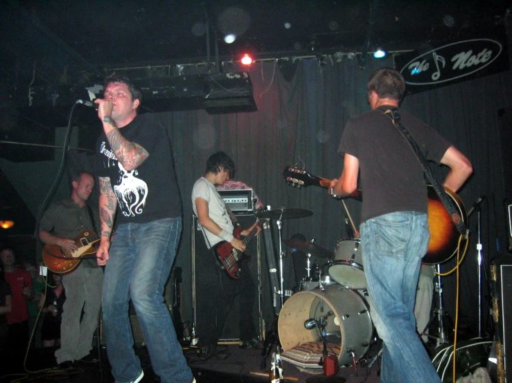 two men singing on a stage with an instrument