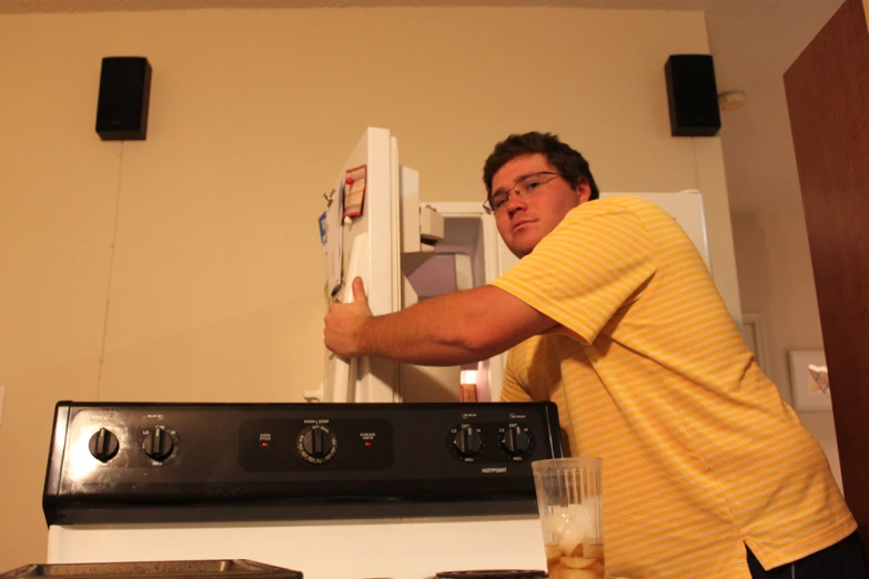 a man opening a refrigerator door to check the contents