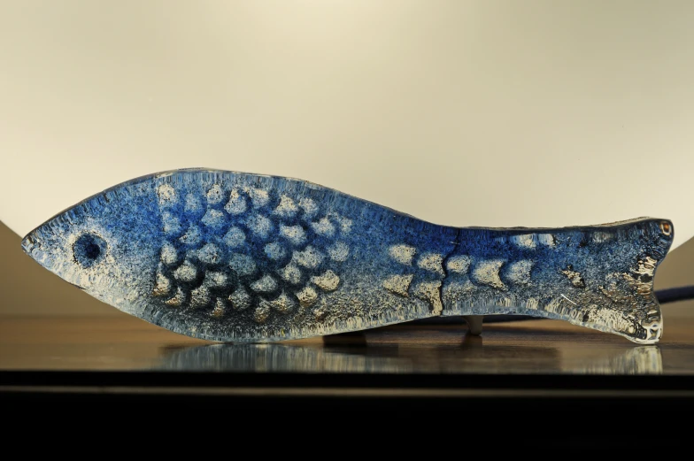 a blue ceramic fish sculpture with white spots