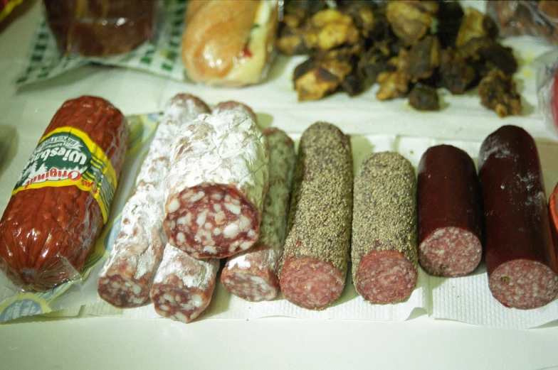 different kinds of salami and sausage sitting on a table