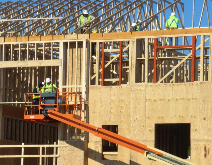 two men standing on a construction site wearing safety vests