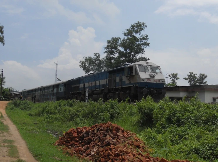 a train traveling along the side of a grass covered hill