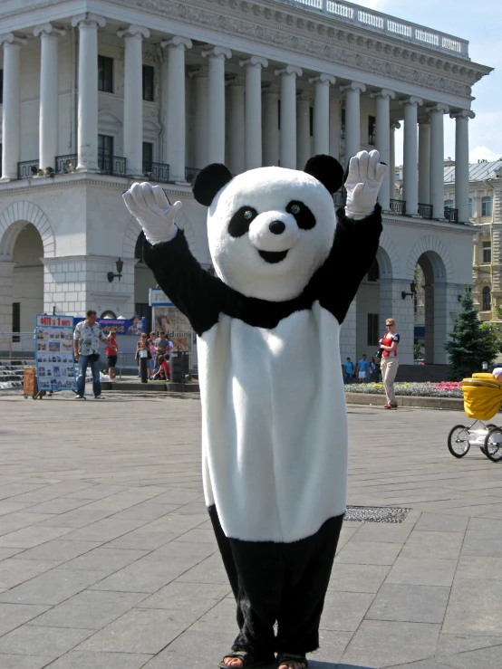 a large panda bear mascot standing on top of a sidewalk