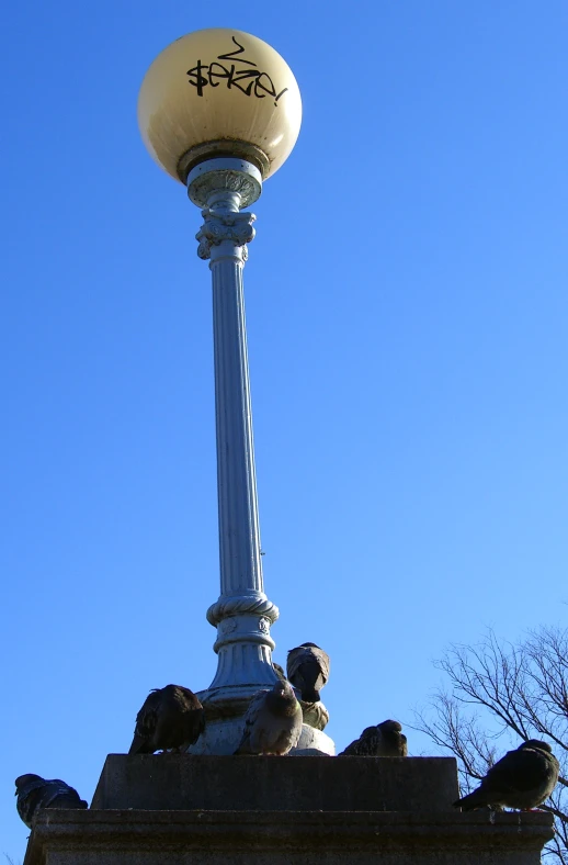 statue in front of a lamp post with a street sign