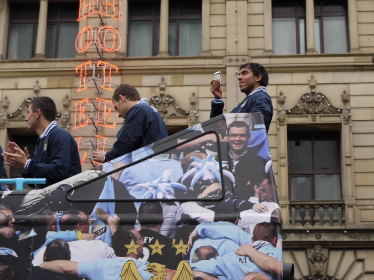 men standing on top of a bus talking and drinking