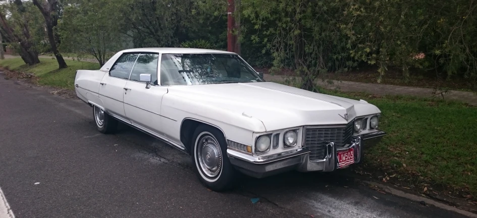 a white car is parked on the side of a road