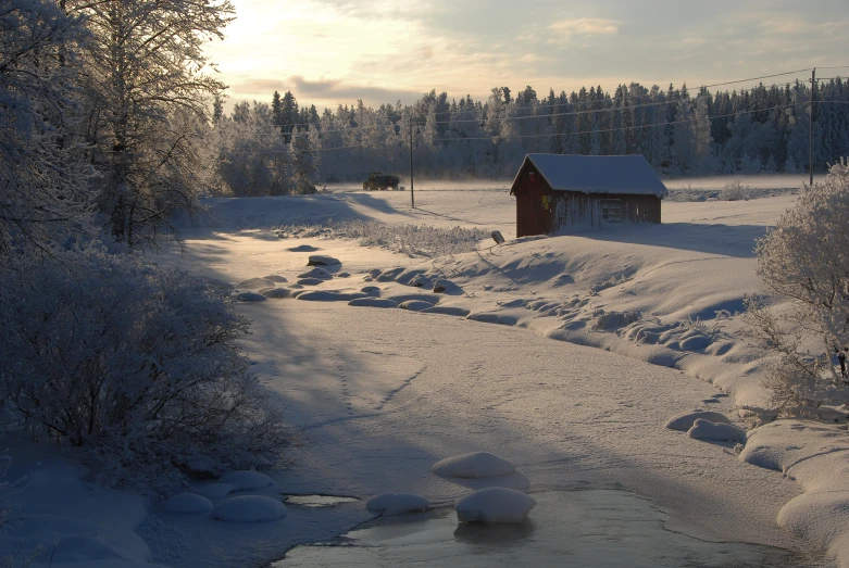 an icy and snowy landscape with a small cabin next to the water