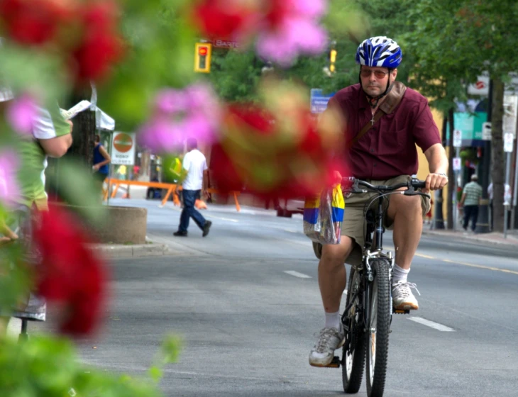 a man riding on a bike down the road