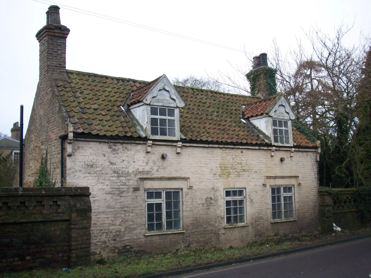 a brown brick house with three chimneys and three windows