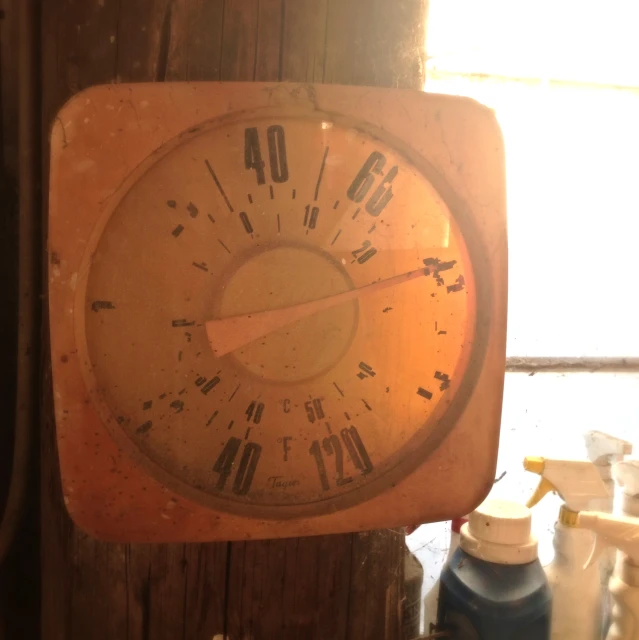 an old clock sits on a wooden table