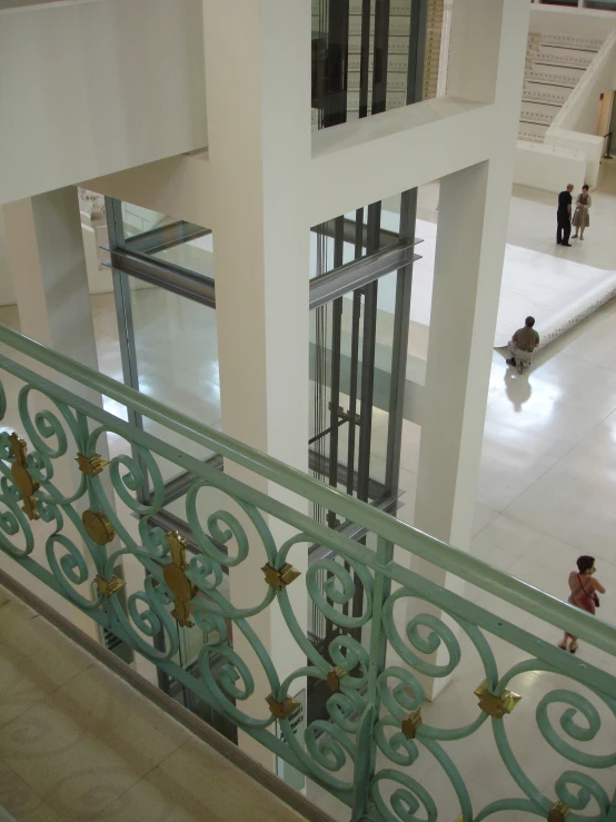 two people are walking on the stairs in a building