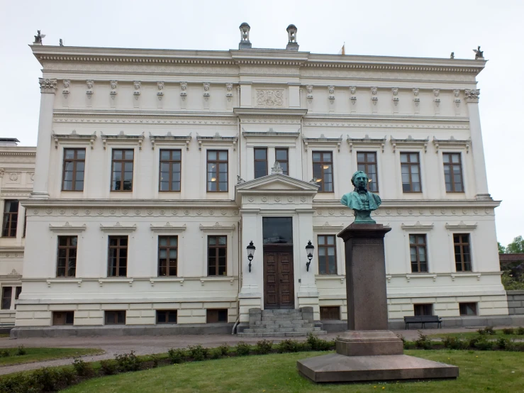 a statue in front of a very tall building