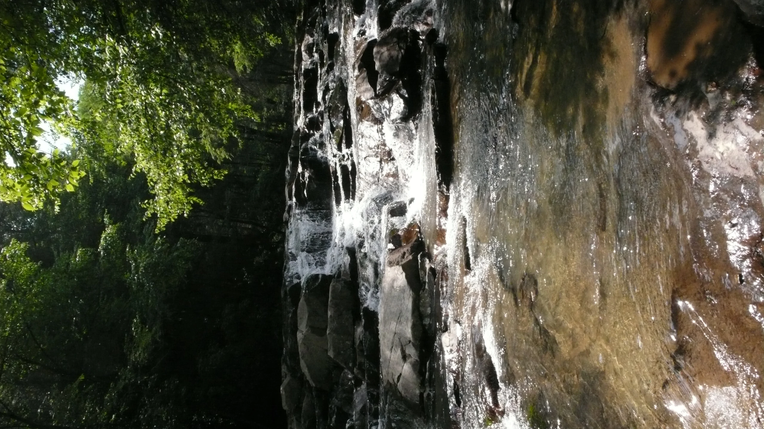 a stream flows among the rocks and trees