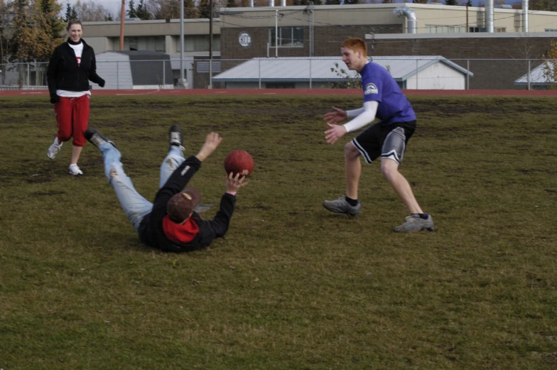 a man playing with a football and another person catching the ball