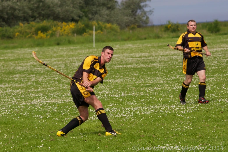 two men in uniforms playing a game of lacrosse