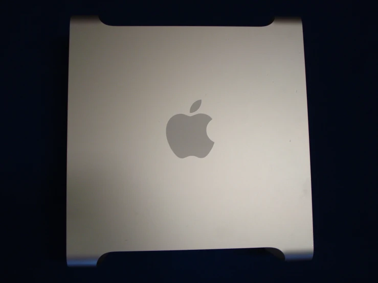 an apple computer that is lit up in the dark