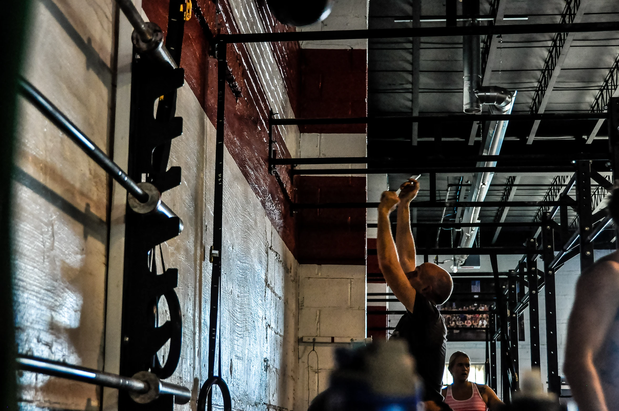 a woman holding a bar in a gym