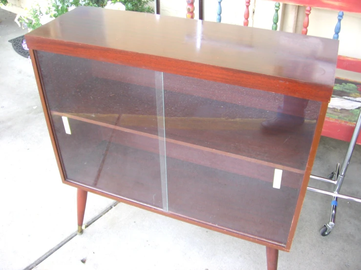 an old looking dresser sitting on a sidewalk