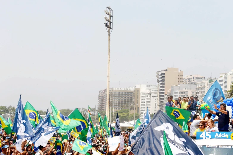 a large crowd in the city holding flags