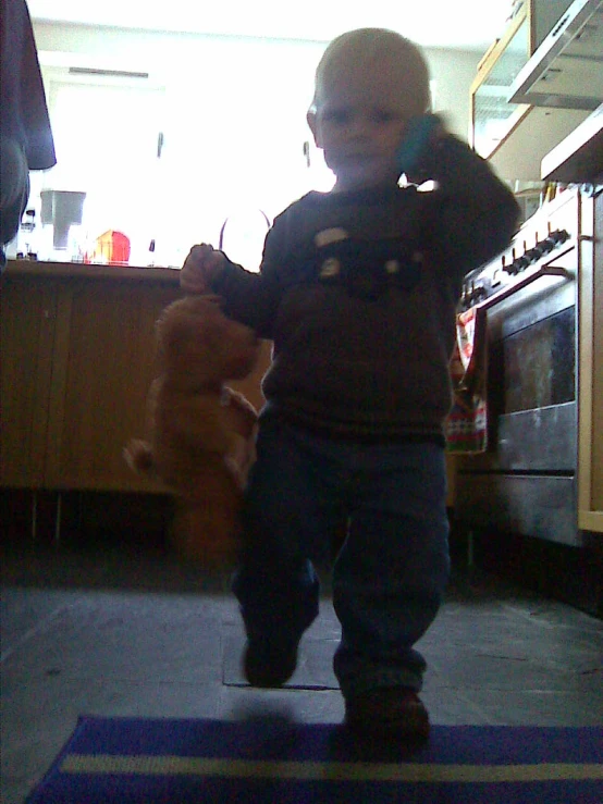 a child holds up a teddy bear in the back