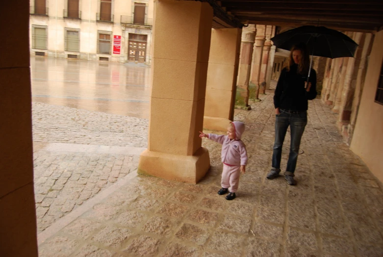 a little girl that is holding a umbrella