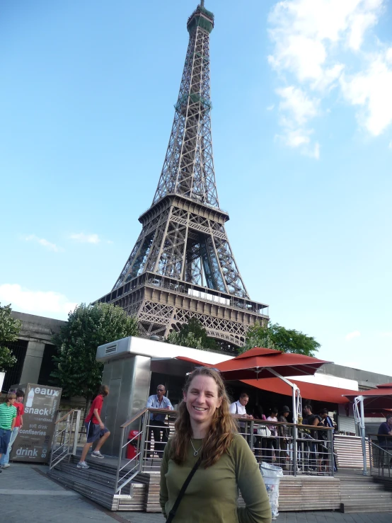 a woman stands in front of the eiffel tower