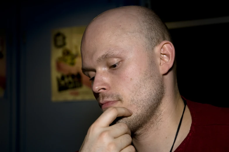 man with short beard in a red shirt and black necklace