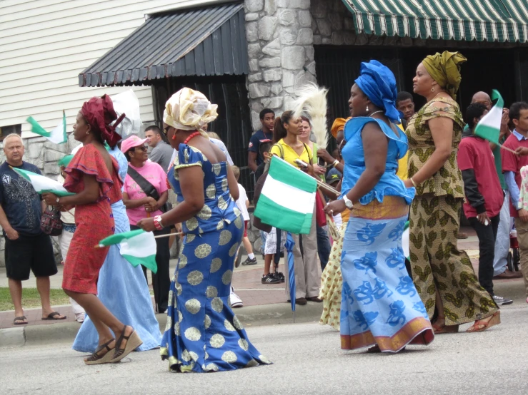 women are standing outside carrying flags and talking