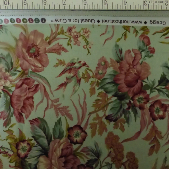 the pattern shows flowers and leaves on a green background