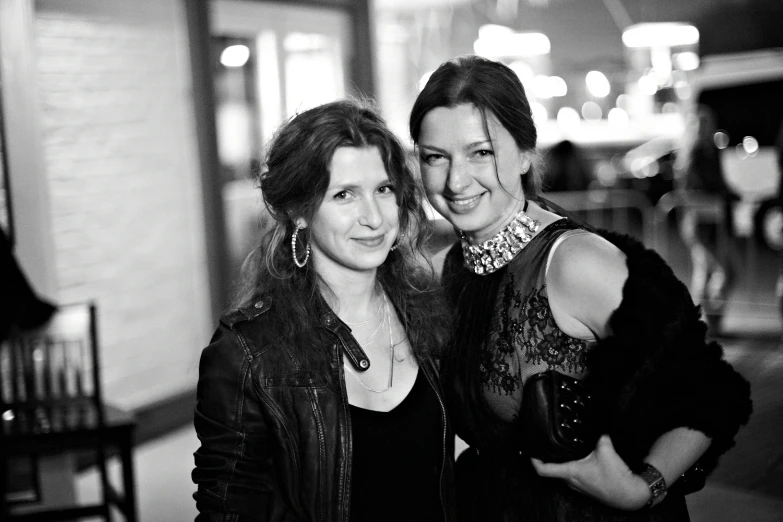 two women smile together while posing for the camera