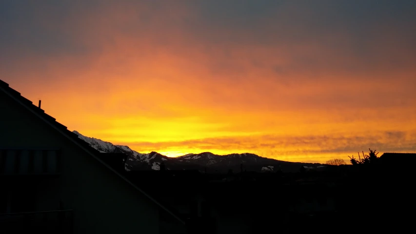 an orange and yellow sunset in a residential neighborhood