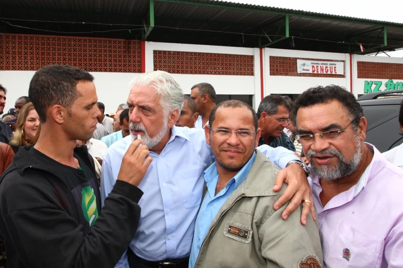 some men with glasses are posing together in front of a building