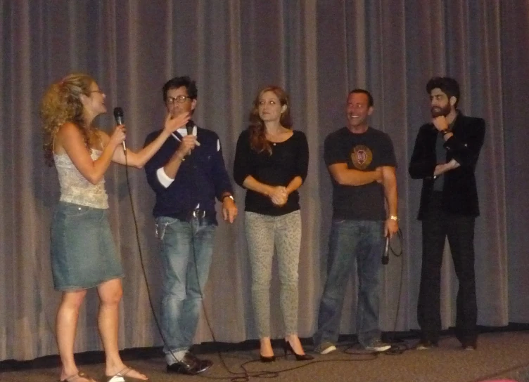 a group of people are standing in front of a curtain