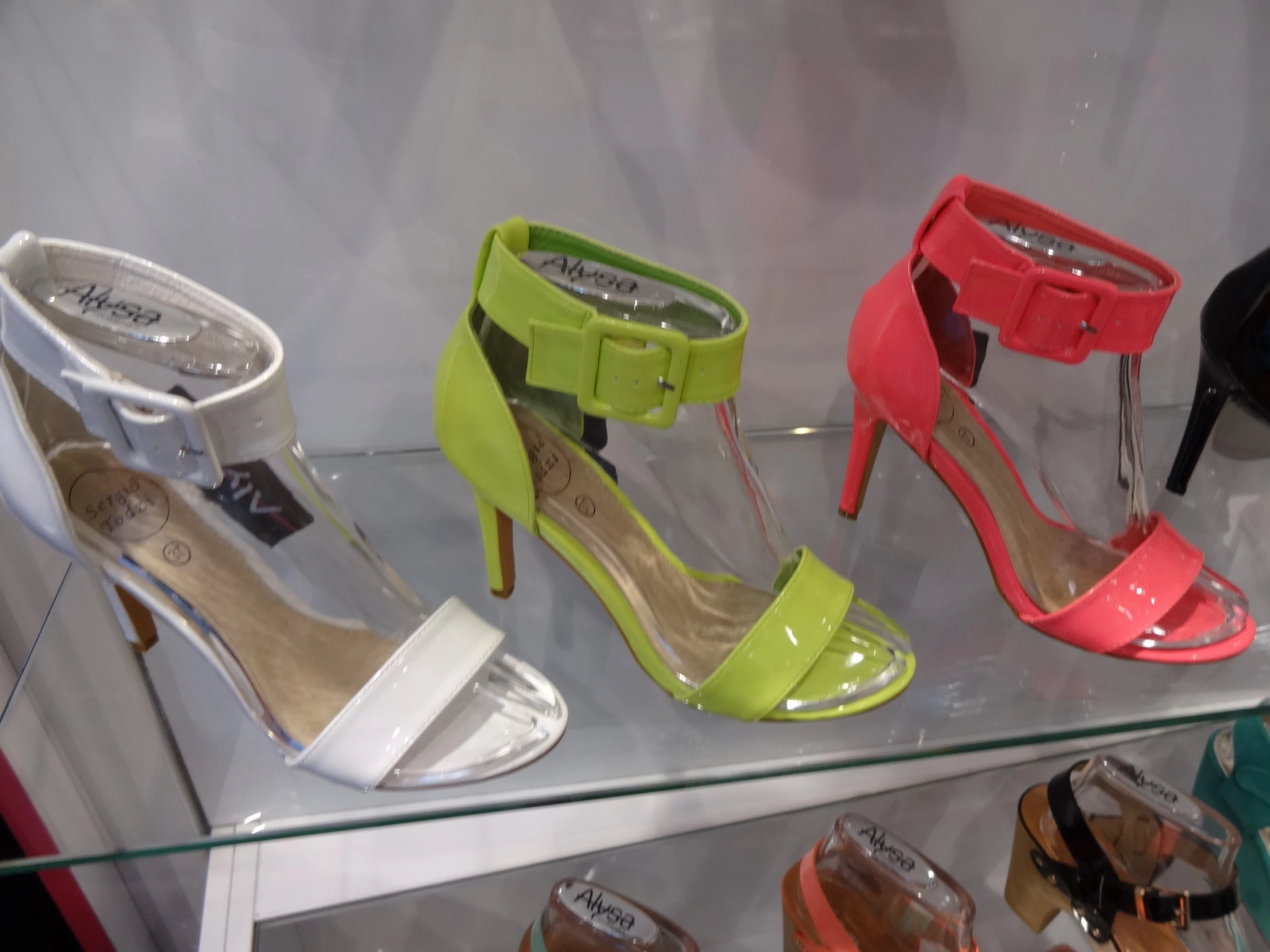 several pairs of shoes are displayed on glass shelves