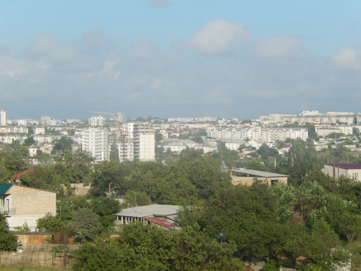 the view from a hill with white building and trees