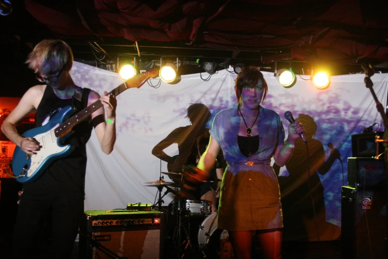 two young men on a stage with guitar instruments