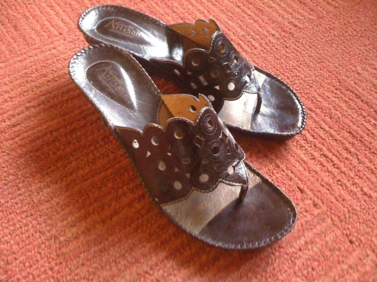 a pair of shoes with brown, white, and gray laces