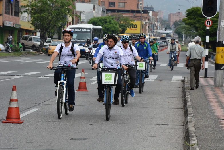 a large group of bicyclists ride down the street