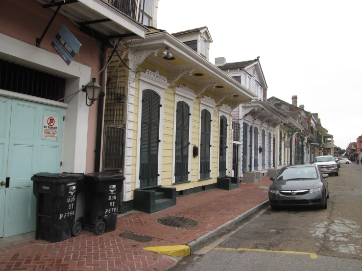 a car driving past three colorful buildings on the street