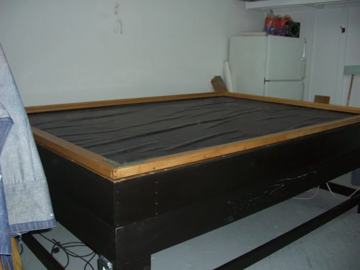 a big bed frame in a very messy bedroom